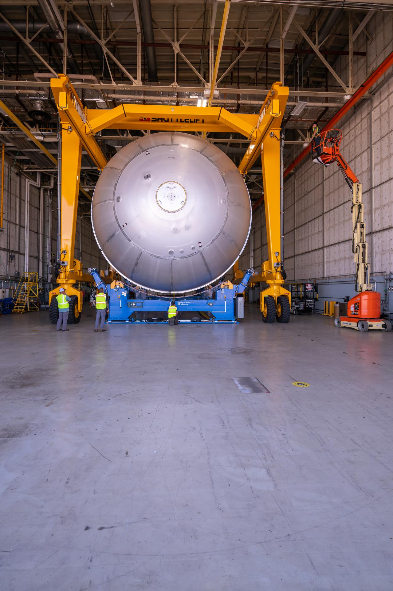 Teams at NASA’s Michoud Assembly Facility in New Orleans move a liquid oxygen tank from the main rocket factory into the adjacent vertical assembly building. The liquid oxygen tank, which will form part of the SLS (Space Launch System) rocket for NASA’s Artemis IV mission to the Moon, is rotated from a horizontal to a vertical configuration and loaded into the high bay’s hydrostatic proof testing cell. This non-destructive evaluation method tests the structural integrity of the tank’s welds by filling the tank with water, simulating the propellant used during launch. The propellant tank will hold more than 196,000 gallons of super-cooled liquid oxygen at launch and is one of five major elements that make up the 212-foot-tall SLS rocket stage. The core stage, along with its four RS-25 engines at its base, produces more than two million pounds of thrust to help launch NASA’s Orion spacecraft, astronauts, and supplies beyond Earth’s orbit and to the lunar surface for Artemis.